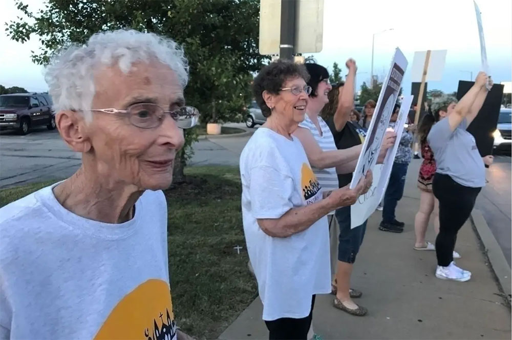 Catherine's Caring Cause Nuns holding signs to support migrants